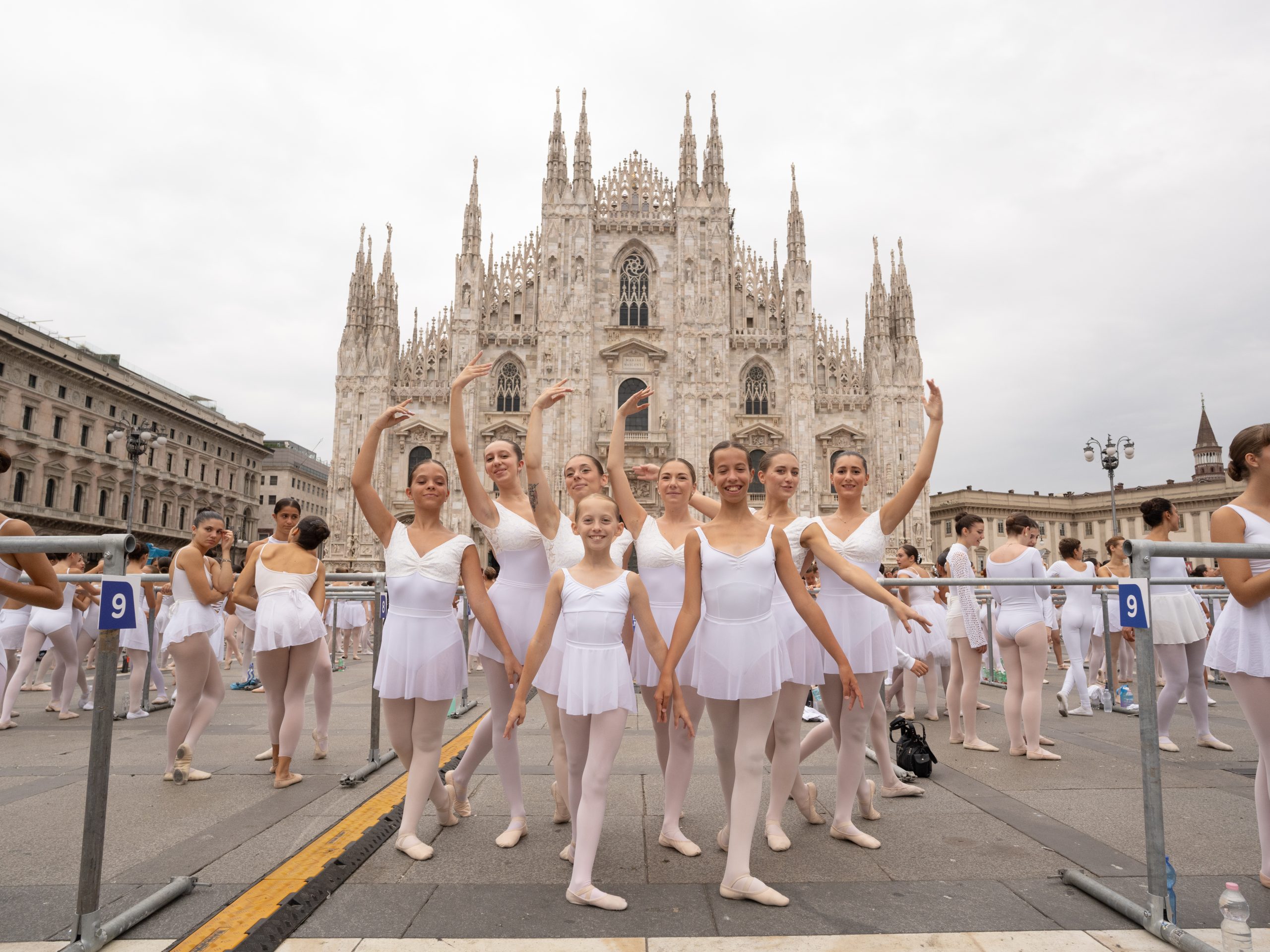 gruppo di ballerine vestite di bianco e in posa davanti al duomo di Milano